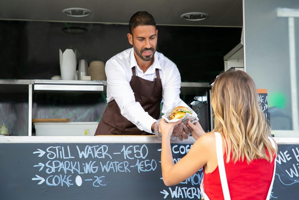 a man handing a sandwich to a woman